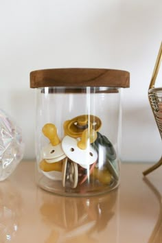 a glass jar filled with lots of different types of buttons