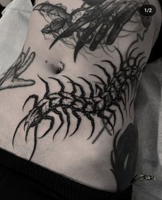 a woman's stomach with black and white tattoos on her body, including leaves