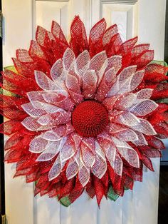 a red and white wreath hanging on the front door