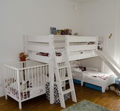 a room with bunk beds and a ladder to the top bed, in front of a window