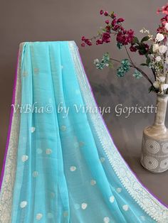 Sky blue and Purple Banarasi Chiffon Silk Saree and Blouse. Capture the captivating beauty of the season with this exclusive Sky blue and Purple Banarasi Chiffon Silk Saree and Blouse. This intricate garment is sure to make a statement of sophistication and luxury. Perfect for special occasions or everyday, add this piece to your wardrobe and experience the elegance and beauty of the highest quality. Blue Cotton Silk Blouse Piece With Sheer Dupatta, Festive Blue Tissue Silk Blouse Piece, Blue Organza Blouse Piece With Cutdana, Blue Chanderi Traditional Wear With Sheer Dupatta, Elegant Blue Cotton Silk Blouse Piece, Blue Blouse Piece In Tissue Silk With Traditional Drape, Blue Traditional Wear With Sheer Dupatta In Tissue Silk, Designer Blue Organza Blouse Piece, Designer Blue Cotton Silk Blouse Piece