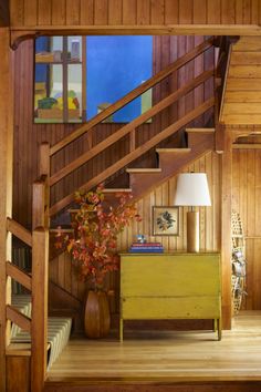 the stairs in this house are made of wood and have been painted yellow with red leaves