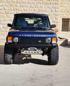 a blue land rover parked in front of a building