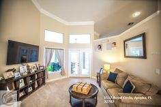 a living room filled with furniture and a flat screen tv on top of a wall