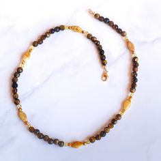 17.5" total length clasp and sterling silver with gold vermeil beads. All genuine Tiger eye, rutile gold, and yellow calcite gemstones if you need it sized, feel free to message me Tiger’s Eye is a golden-brown banded variety of quartz that exhibits chatoyancy, or the “cat’s eye effect”–a luminous streak that moves as you rotate the stone. Tiger Eye is a stone often feared and revered for being an all seeing and all knowing eye. It is said to grant the wearer with a keen ability of observation t Gold Rondelle Beaded Necklace With Natural Stones, Gold Single Strand Agate Necklace, Gold Agate Beaded Necklace With Polished Beads, Gold Agate Single Strand Beaded Necklace, Gold Citrine Beaded Necklace For Gift, Handmade Baltic Amber Gold Necklaces, Gold Agate Gemstone Beaded Necklaces, Gold Agate Beaded Necklace With Gemstones, Gold Agate Beaded Necklace With Natural Stones