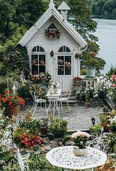 a small white house surrounded by lots of flowers