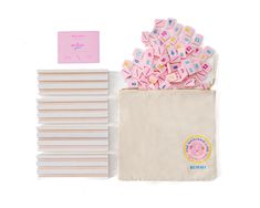 a bag filled with lots of pink and white candy next to a pile of stickers