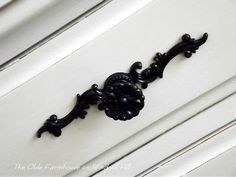 an old fashioned door handle on the side of a white painted house with black trim