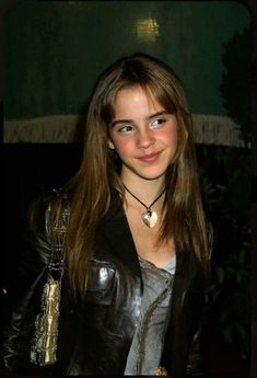 a young woman with long hair wearing a leather jacket