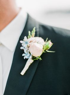 a man in a suit with a boutonniere and flowers on his lapel