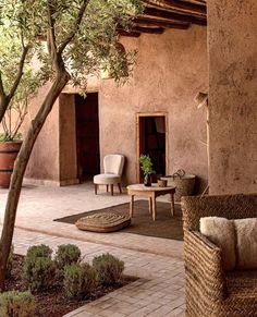 an outdoor patio with wicker furniture and potted trees