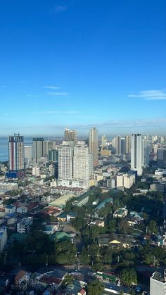 an aerial view of a city with skyscrapers and water in the background, taken from above