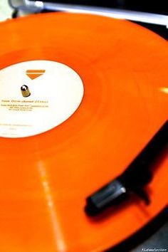 an orange record player with a black object on it