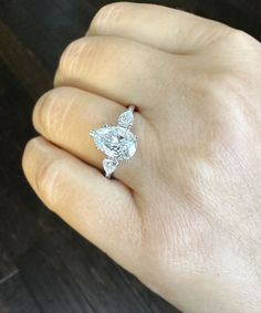 a woman's hand with a diamond ring on it