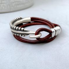 This stylish leather bracelet features silver accents for a rustic yet modern look. Crafted from high-quality leather and durable metal. Suitable for both men and women, this versatile piece is perfect for everyday wear or casual occasions. SIZE GUIDE Each bracelet is custom-made to fit your wrist To know your wrist length, measure your wrist by wrapping a flexible measuring tape around your wrist, be sure is snug, and measure the length of the wrist circumference Please DON'T ADD EXTRA SPACE to Silver Leather Double Band Bracelets, Unique Silver Leather Bracelet, Silver Leather Bracelet, Silver Bracelet For Men, Street Jewelry, Simple Leather, Bracelet For Men, Measuring Tape, Leather Cuffs