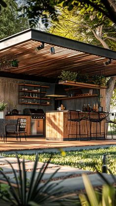 an outdoor kitchen with wooden cabinets and barstools in the middle of a yard