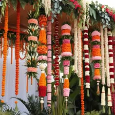 an arrangement of flowers and garlands hanging from the ceiling