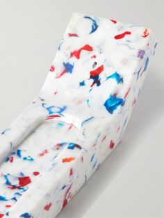 a close up of a white and red object with blue, red, and white paint splattered on it