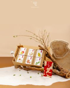 an assortment of items are displayed on a white tablecloth with a tree branch in the foreground