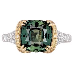 This ring is a stunning piece that combines elegance with uniqueness. The 4.50 carat cushion-cut Green Sapphire at the center is not only impressive in size but also comes with a GIA certification, ensuring its quality and authenticity. The green hue adds a rare and captivating touch. The center green sapphire is flanked by 0.24 carats round yellow diamonds and set in yellow gold. An additional 0.36 carats white diamonds decorate the side shank. All these combine to create a visually striking an Green Montana, Brilliant Cut Diamond Ring, Green Sapphire Ring, Yellow Diamonds, Buying An Engagement Ring, Sapphire And Diamond Ring, Fine Diamond Jewelry, Diamond Fashion Rings, Vintage Style Rings