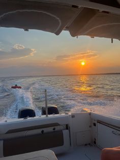 the sun is setting over the water on a boat