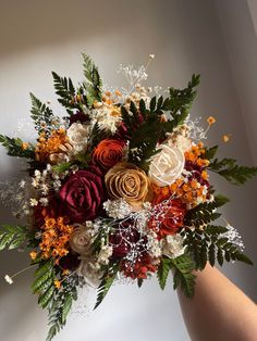 a person holding a bouquet of flowers in their hand