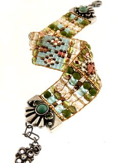 CHILI ROSE OF SANTE FE (Adonnah Langer) This sterling silver beaded bracelet was designed and made by Adonnah Langer of Chili Rose Beadz. Her rich colors and intricate designs are made with Czech glass and delicate beads of all shapes and colors. The sterling silver lobster and chain make this bracelet adjustable. -Gorgeous Floral Turquoise Sterling Silver End Tips Mix of Turquoise soft Pastels & Freshwater pearl Adjustable to approximately 7 3/4 inches -Sterling handcrafted chain with "flow Fusion Style Polished Beaded Bracelets For Gifts, Fusion Style Polished Beaded Bracelets As Gift, Fusion Style Polished Beads Bracelet As Gift, Artisan Silver Beaded Bracelets With Unique Variations, Fusion Style Handmade Beaded Bracelets With Round Beads, Artisan Beaded Bracelets With Silver Beads For Gift, Handmade Fusion Bracelet With Round Beads, Artisan Czech Glass Jewelry Bracelet, Silver Beaded Bracelets With Unique Variations