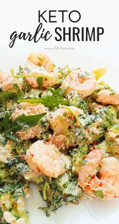 a white plate topped with broccoli and shrimp