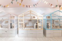 three wooden dollhouses are on display in a room