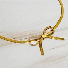 Indulge in the timeless elegance of our Herringbone Chain Bow Anklet. The classic herringbone chain is paired with a modern and delicate bow design, offering both sophistication and style. Add a touch of charm to any outfit with this must-have accessory.Dimensions: approximately 8.25" with a 2" extender18k gold plated brassLead and Nickel freeMade In: ChinaMaterial Composition: 18k gold plated brass Herringbone Chain, Bow Design, Knit Set, Mozambique, Herringbone, Anklets, Bosnia And Herzegovina, Timeless Elegance, 18k Gold