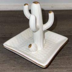 a white ceramic cactus sitting on top of a wooden table