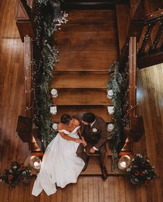 a bride and groom are kissing on the stairs