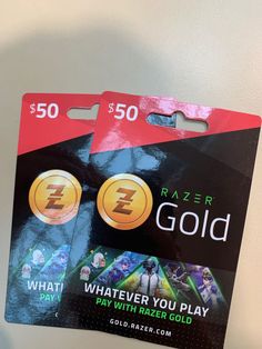 two $ 50 razer gold cards sitting next to each other