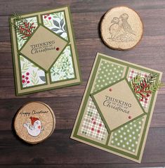 three christmas cards on a table next to a wood slice