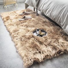 a furry rug on the floor in front of a bed with high heeled shoes