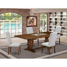 a dining room table with chairs and a chandelier in front of a brick wall