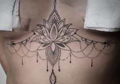 a woman's back with a tattoo design on her lower back and the bottom part of her stomach