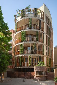 an apartment building with plants growing on the balconies