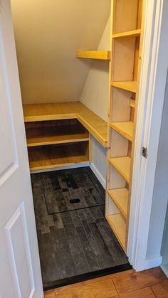 an empty walk in closet with shelves on the wall and tile flooring underneath it