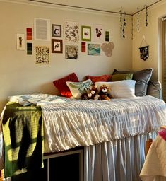 a bed sitting in a bedroom next to a window with pictures on the wall above it