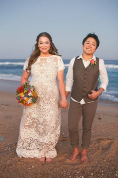 two people standing next to each other on a beach