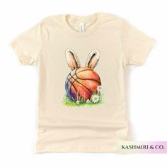 "Kids will love this \"EASTER BASKETBALL BUNNY\" youth short sleeve tee. This lightweight side-seamed shirt maximizes comfort all day long.  Easter Basketball Bunny Kids Shirt, Funny Easter Sports Tee, Kids Sports Gift, Bunny Player TShirt, Game Day Tee, Ball Player, Kids Gift 🌟100% Airlume combed and ringspun cotton (fiber content may vary for different colors) 🌟Light fabric (4.2 oz/yd² (142 g/m 🌟Retail fit RETURNS: All products are made-to-order and because of the nature of these items, all sales are final unless they arrive damaged or defective. CARE INSTRUCTIONS Turn Inside Out. Machine wash: cold (max 30C or 90F); Non-chlorine: bleach as needed; Tumble dry: low heat; Iron, steam or dry: medium heat; Do not dryclean. PLEASE SEE THE SIZING CHARTS for the measurements, and please cons Spring Sports T-shirt Pre-shrunk, Playful Sports T-shirt For Summer, Basketball T-shirt With Sublimation Print, Playful Short Sleeve Sports T-shirt, Fun White Sports T-shirt, Fun Sports Short Sleeve T-shirt, Fun Sports T-shirt With Short Sleeves, Fun Sports T-shirt Short Sleeve, White T-shirt For Spring Sports Events