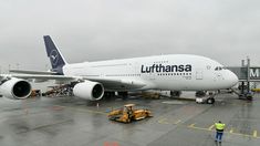 a large jetliner sitting on top of an airport tarmac next to a man