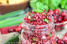 a jar filled with cranberry pomegranate surrounded by other fruits and vegetables