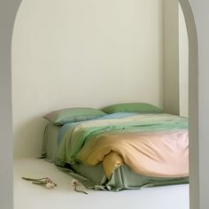 a bed sitting in the corner of a room next to a wall with an arch