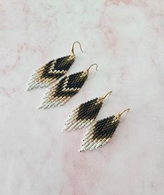 three pairs of beaded earrings sitting on top of a table