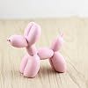 a pink poodle toy sitting on top of a wooden table