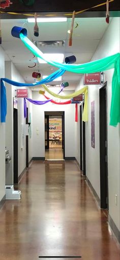 an empty hallway with colorful streamers hanging from the ceiling