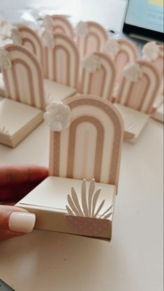 a hand is holding a miniature model of a chair with flowers on the front and back