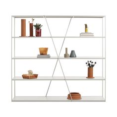 a white book shelf filled with books and vases